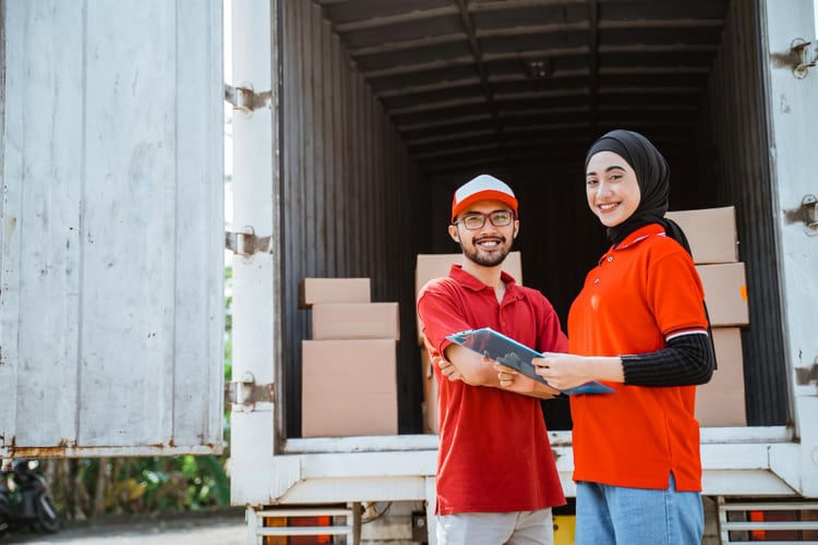 Dua Orang Sedang Mencatat Pengadaan Barang